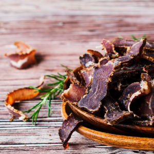 Biltong and rosemary with wooden bowl.